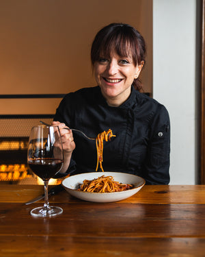 Image of Chef Giovanna with a plate of puttanesca for the Shop With a Chef series